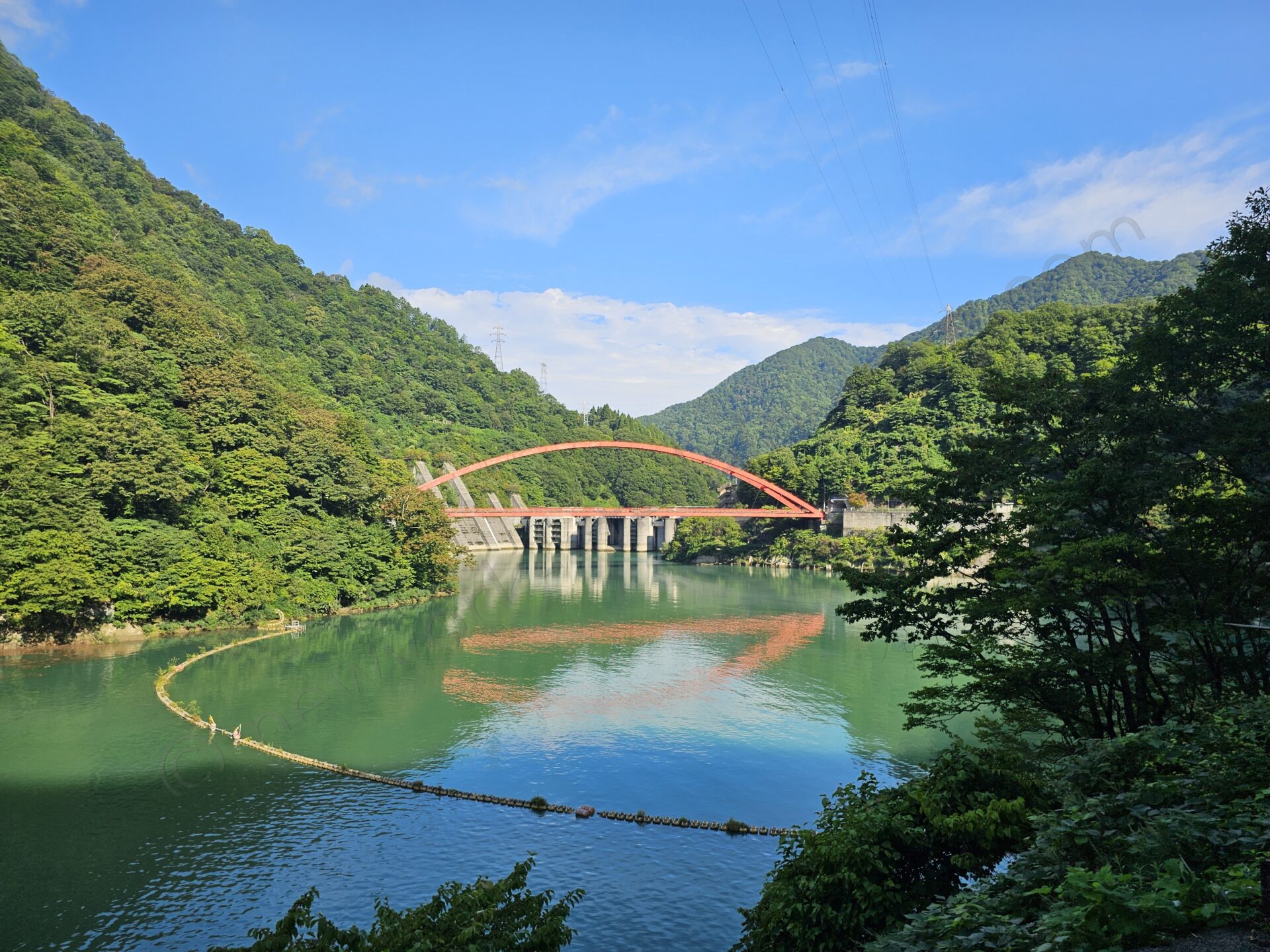 黒部峡谷のダム湖と赤いアーチ橋